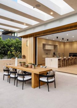 Modern,Open-plan,Kitchen,And,Outdoor,Dining,Space,With,Wooden,Furniture